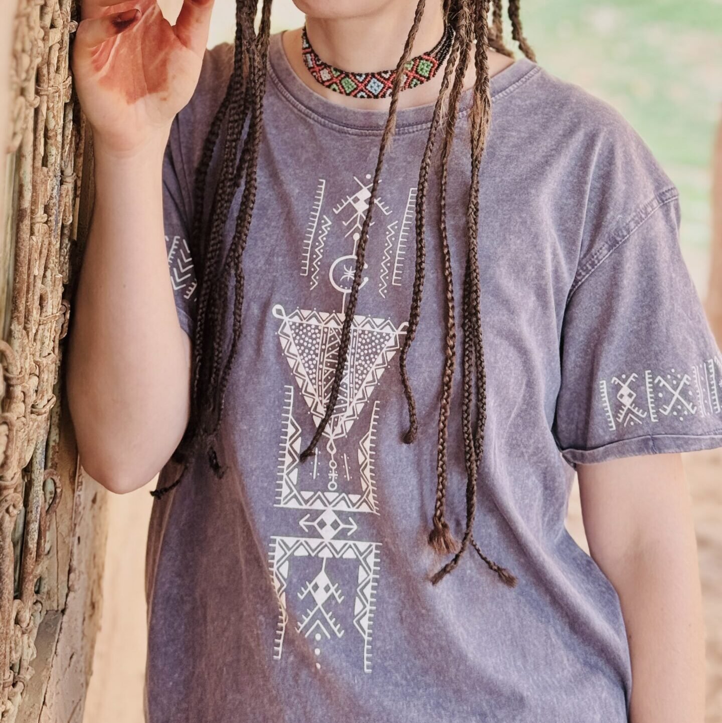 Light blue Amazigh T-shirt with bold Tifinagh script embroidery and geometric tribal motif.