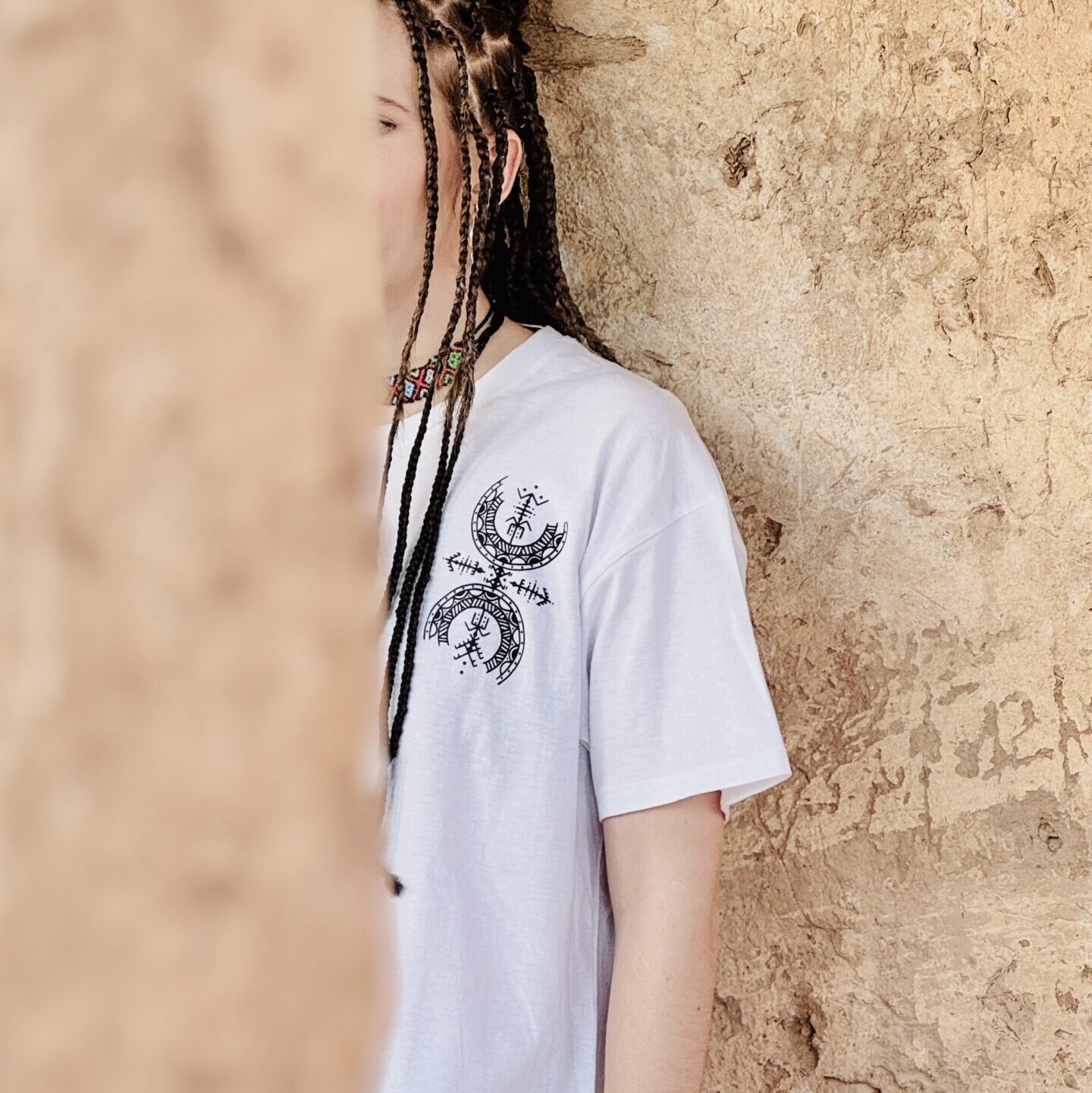 Femme portant le t-shirt en coton Afusart « Symbole de liberté », orné de motifs amazighs originaux.
