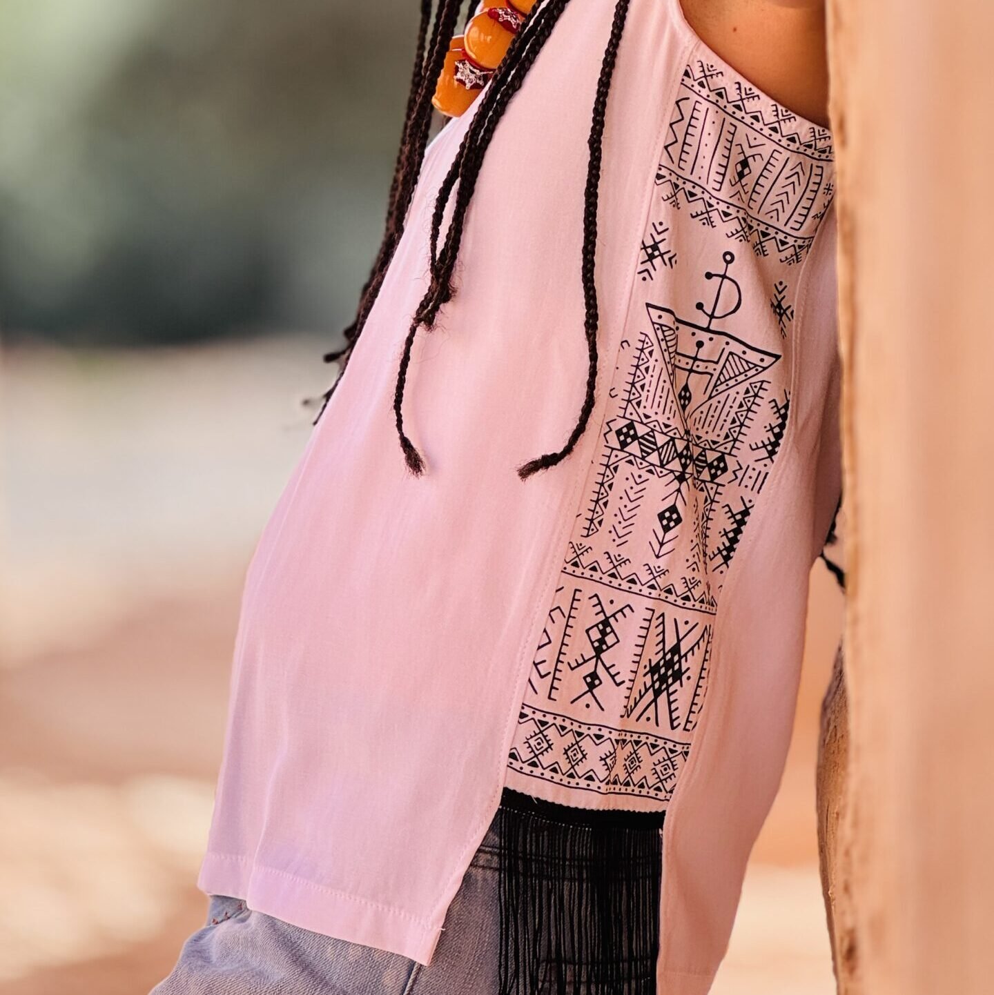 White sleeveless Amazigh top with black geometric design and decorative fringe