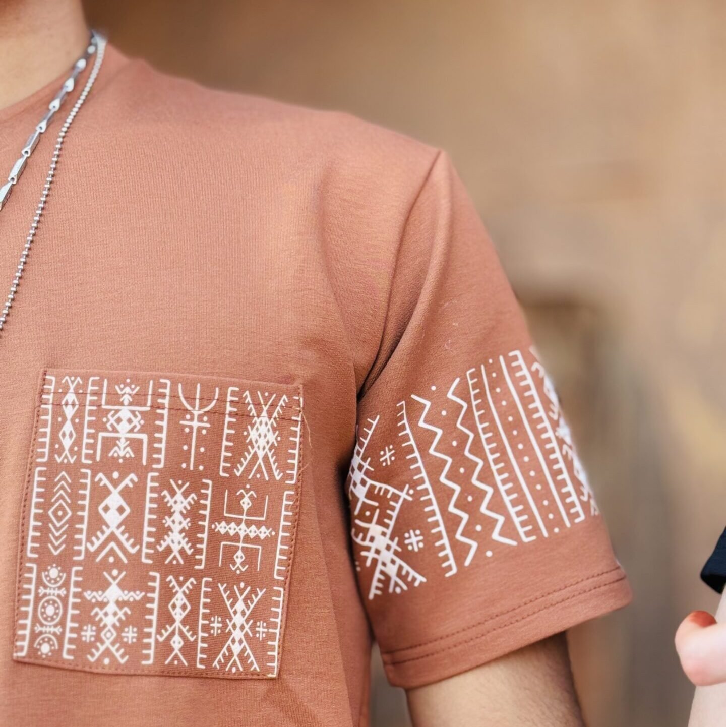 Terracotta Amazigh T-shirt with white geometric motifs on chest pocket and sleeve