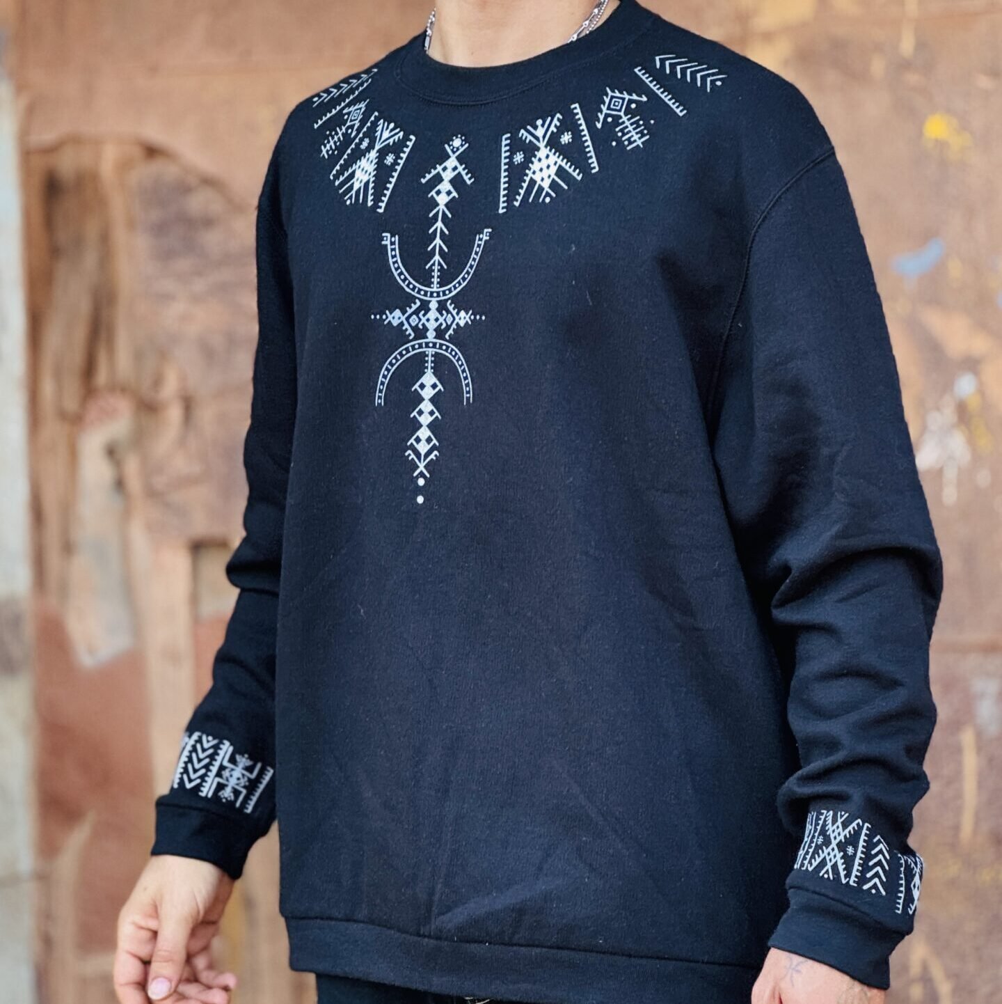 Black Amazigh sweatshirt featuring white geometric motifs and decorative sleeve bands
