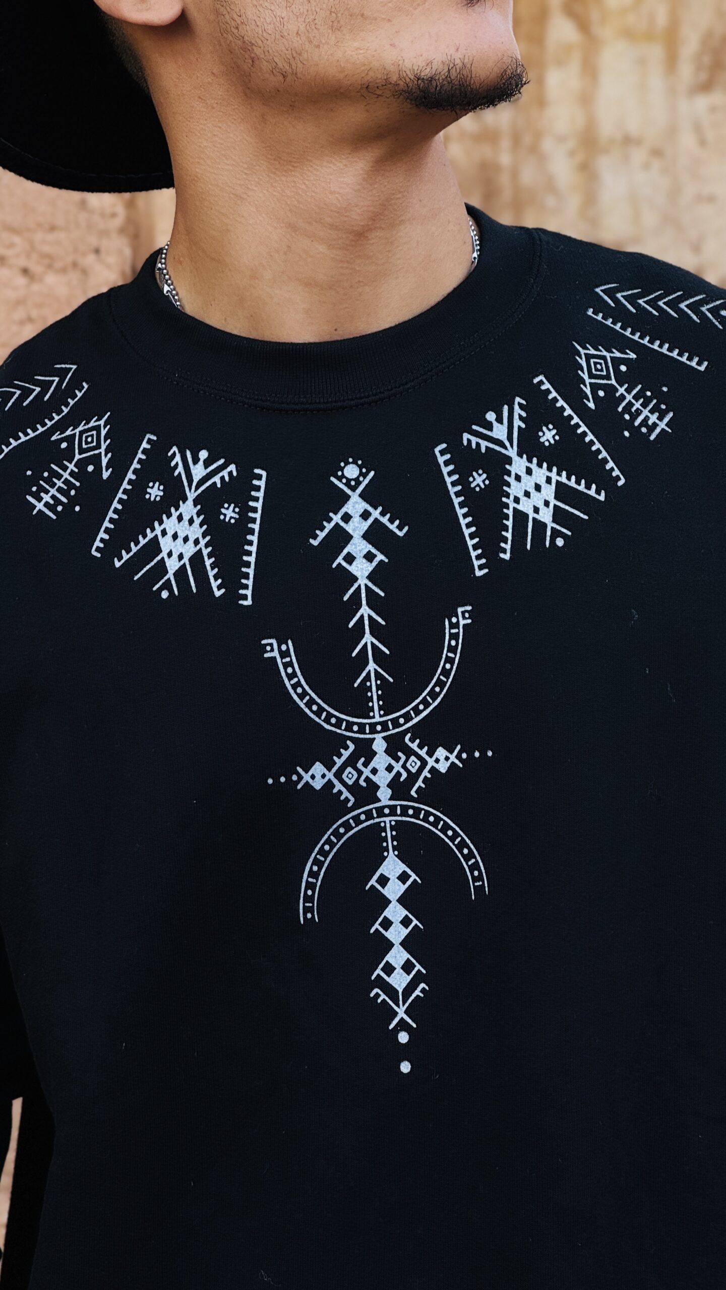 Black sweatshirt with white Amazigh geometric design and decorative sleeve motifs