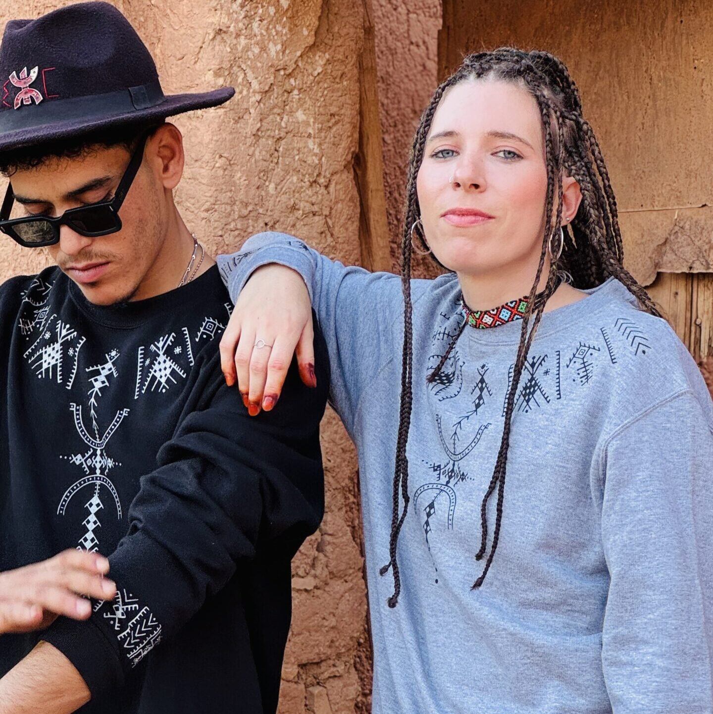 Black and gray sweatshirts featuring contrasting white Amazigh-inspired geometric designs