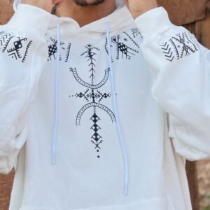 Close-up of black Amazigh geometric design on white fabric