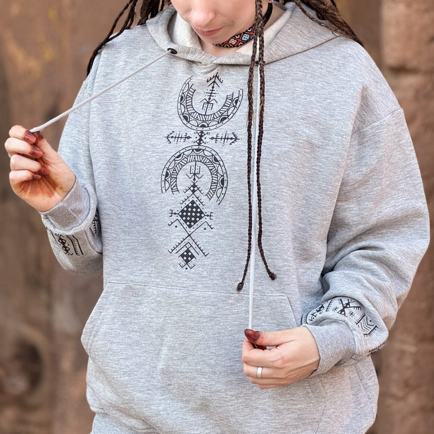 Light gray Amazigh hoodie with black geometric motifs, front drawstrings, and traditional-inspired sleeve details