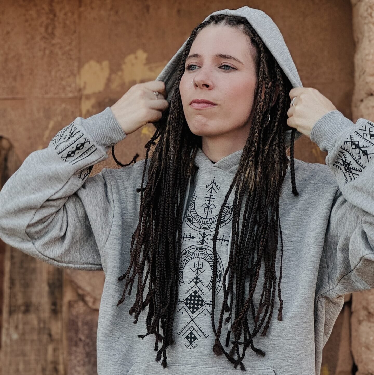 Light gray Amazigh hoodie with black geometric motifs, front drawstrings, and traditional-inspired sleeve design