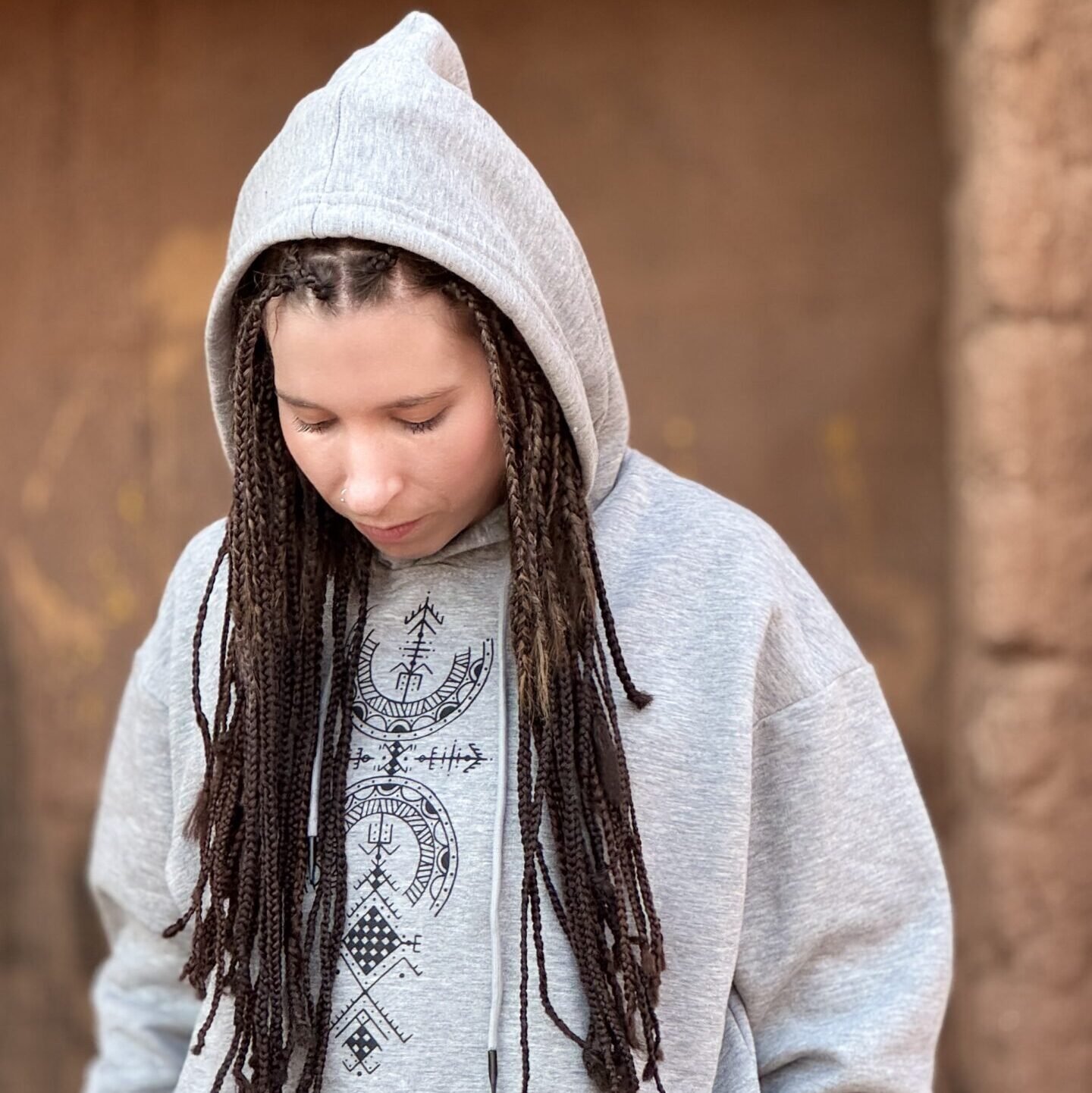 Light gray Amazigh hoodie with black geometric front graphic and traditional-inspired sleeve motifs