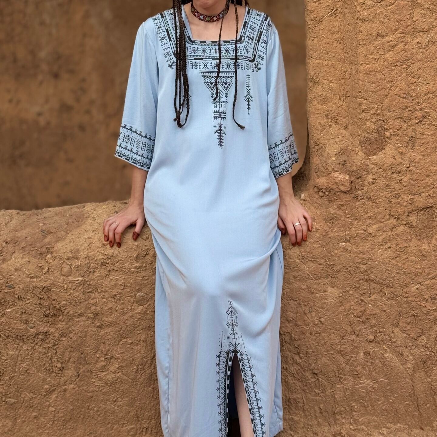 Light blue Moroccan Amazigh dress with black geometric embroidery and traditional patterns
