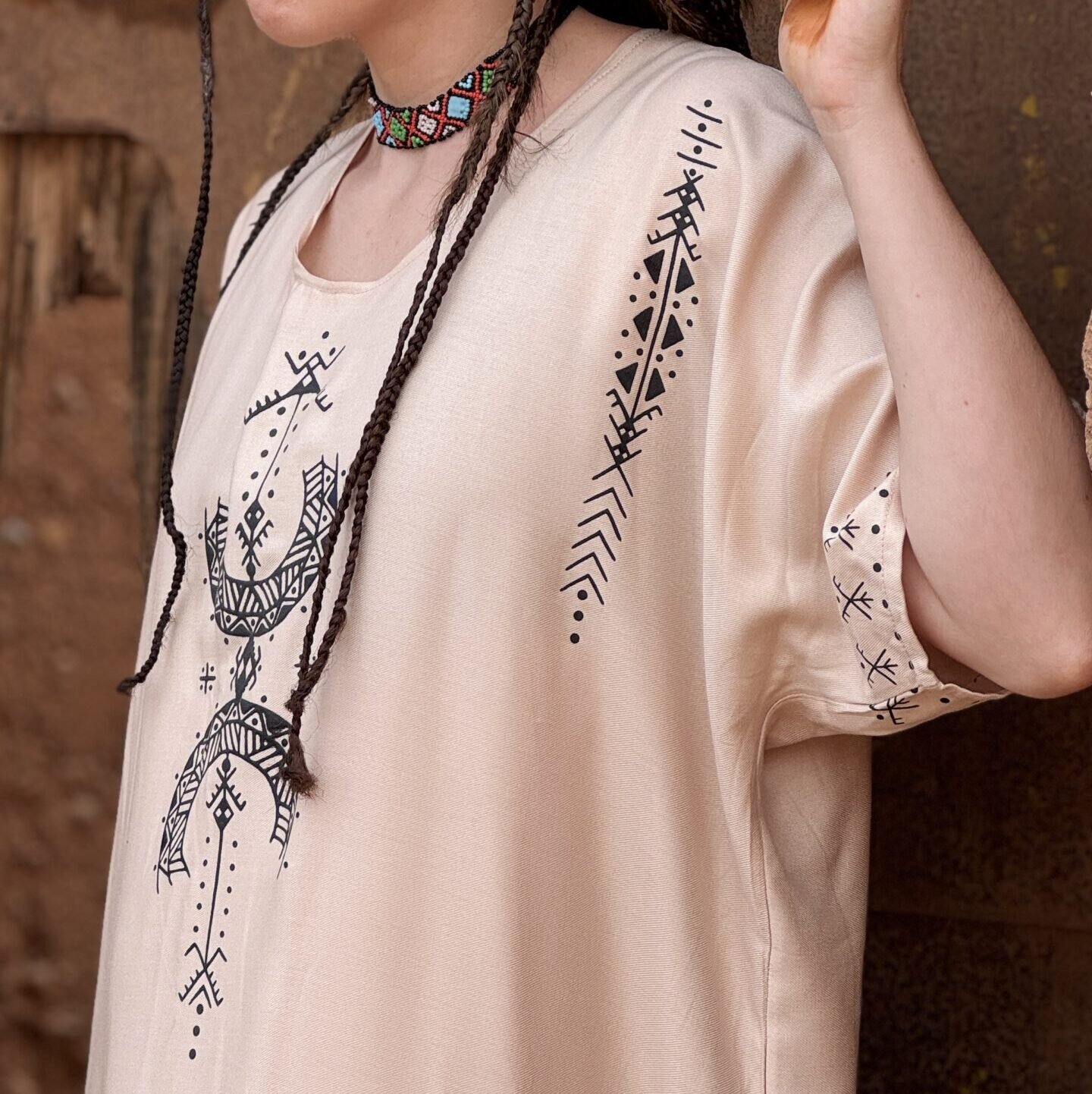 Cream Moroccan Amazigh dress featuring black Aza symbol and traditional geometric embroidery
