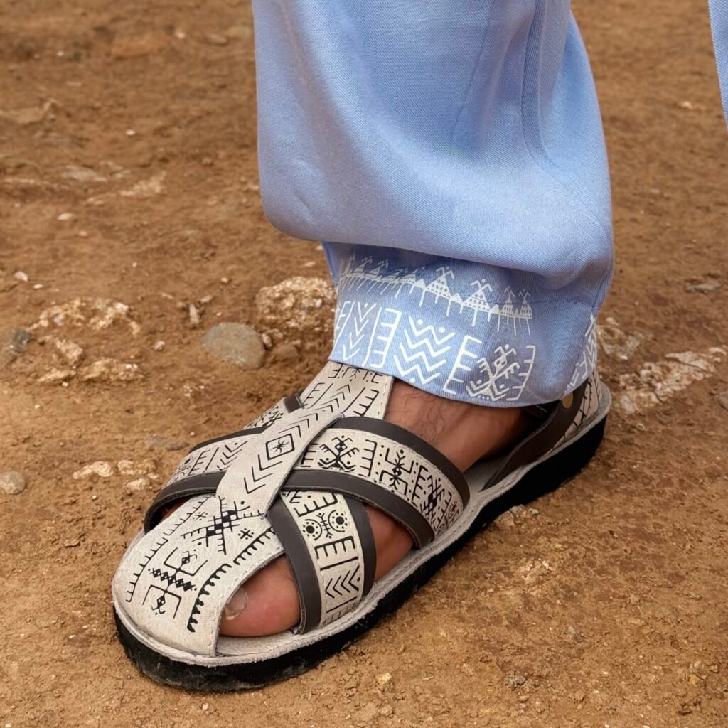 Light blue Moroccan Amazigh pants with white geometric embroidery and traditional patterned sandals