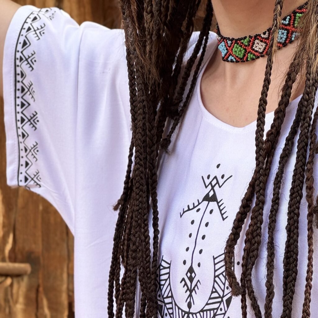 White Moroccan Amazigh dress with black geometric motifs and traditional symbols on sleeves and front