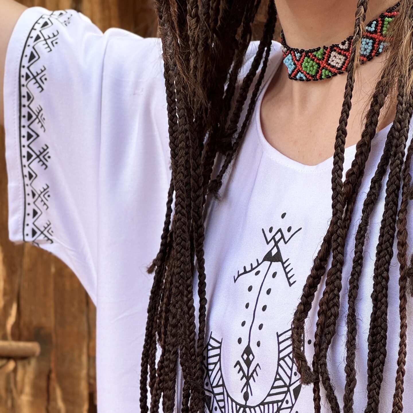 White Moroccan Amazigh dress with black geometric motifs and traditional symbols on sleeves and front