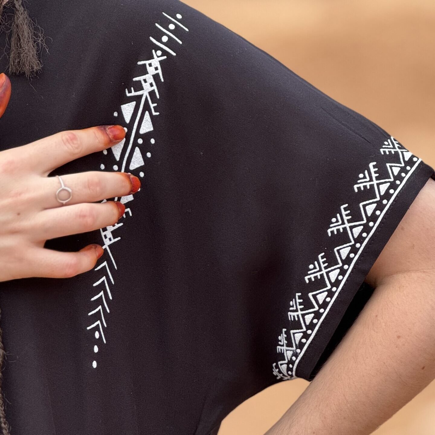 Black Moroccan Amazigh dress with white geometric embroidery and colorful traditional motifs on the sleeves
