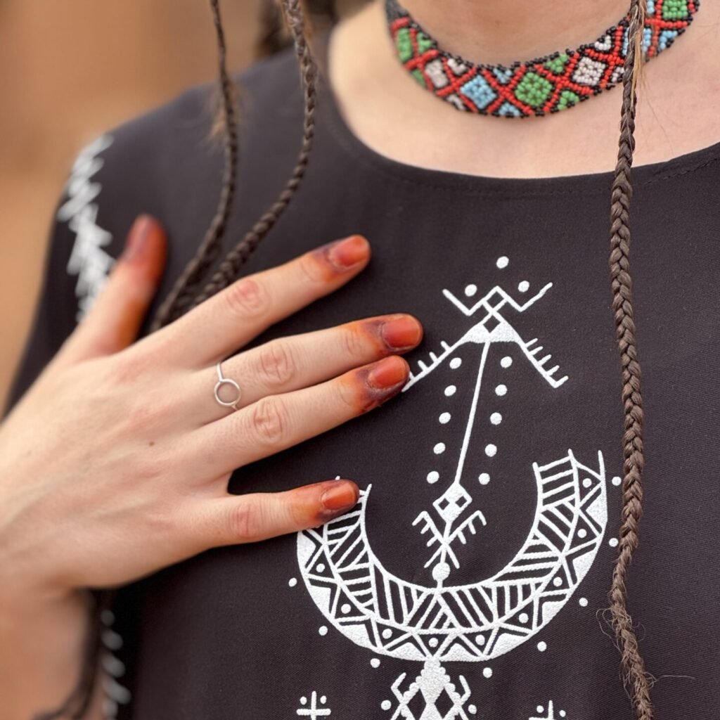 Black Moroccan Amazigh dress with Aza symbol, white geometric embroidery, and colorful traditional motifs