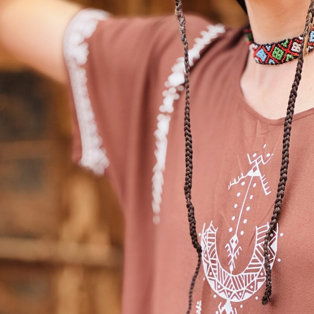 Brown Moroccan Amazigh dress with Aza symbol, white geometric embroidery, and colorful traditional motifs