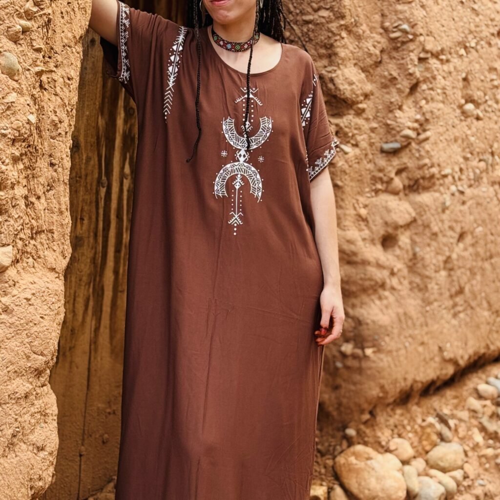 Brown Moroccan Amazigh dress with Aza symbol, white geometric embroidery, and traditional motifs