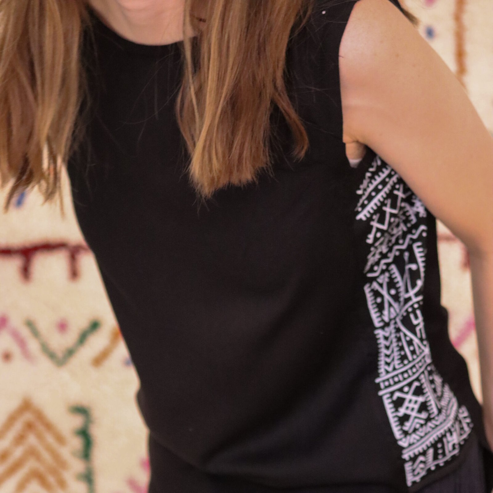 Black sleeveless top with colorful Amazigh geometric patterned panels on the sides