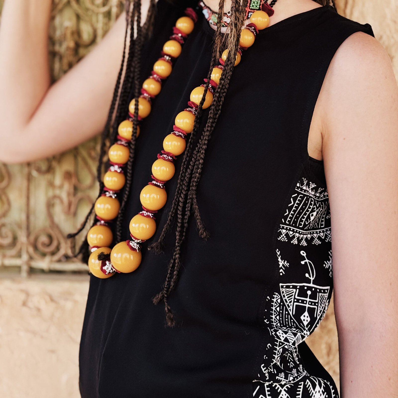 Black sleeveless top with white Amazigh geometric side panels and traditional symbols