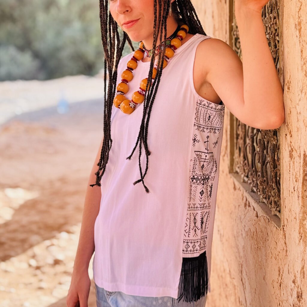 White sleeveless top with black and white Amazigh geometric side panel and fringe