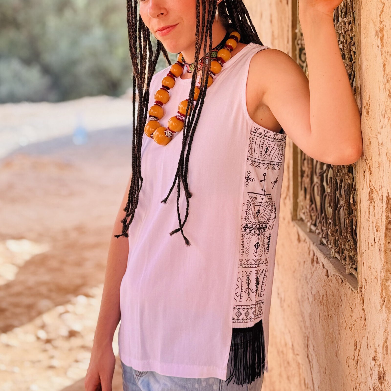 White sleeveless top with black and white Amazigh geometric side panel and fringe
