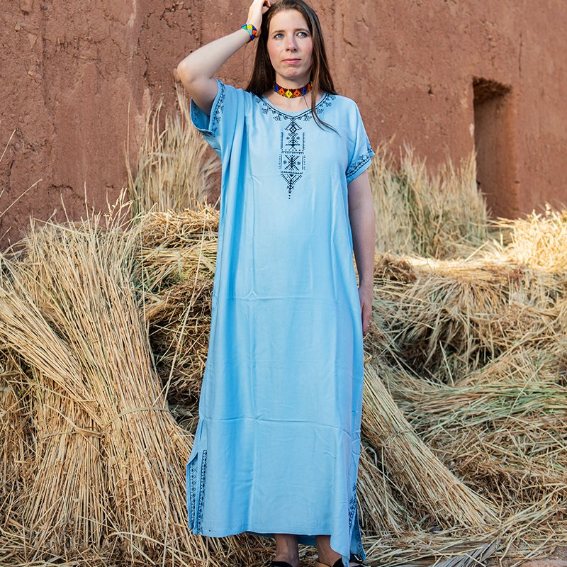 Light blue Amazigh gandora with dark geometric patterns on the neckline, chest, sleeves, and lower sides