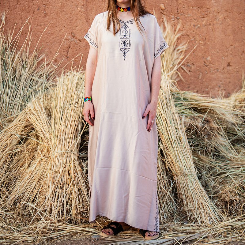 Cream-colored Amazigh gandora with dark geometric patterns on the neckline, sleeves, and lower sides
