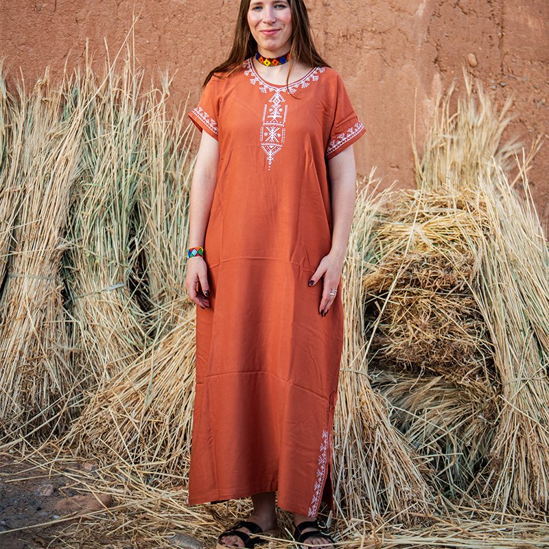 Terracotta Amazigh gandora with white geometric decorative patterns on the neckline and front
