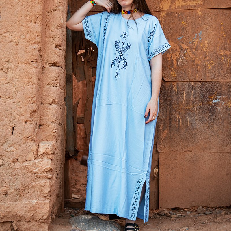 Light blue Amazigh gandora featuring dark AZA symbols and geometric patterns on the front, sleeves, and lower sides