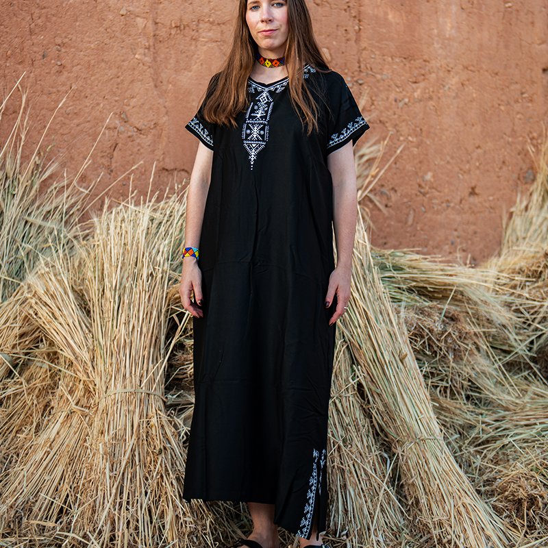 Black Amazigh gandora with white geometric embroidery details.