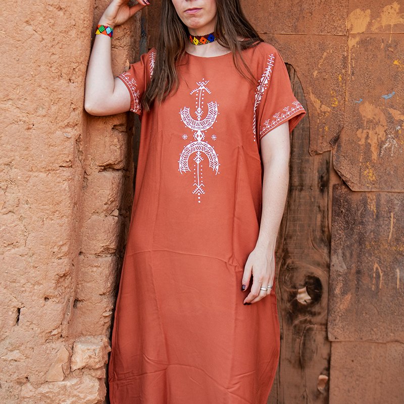 Burnt orange Amazigh gandora featuring white AZA symbols and geometric decorative patterns