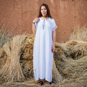 White Amazigh gandora with dark blue geometric embroidery on the neckline, sleeves, and lower sides