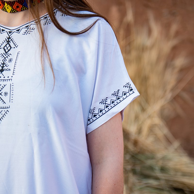 White Amazigh gandora with black geometric patterns on the neckline, chest, and sleeve