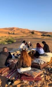 Outdoor art session in the Merzouga desert surrounded by Moroccan sand dunes