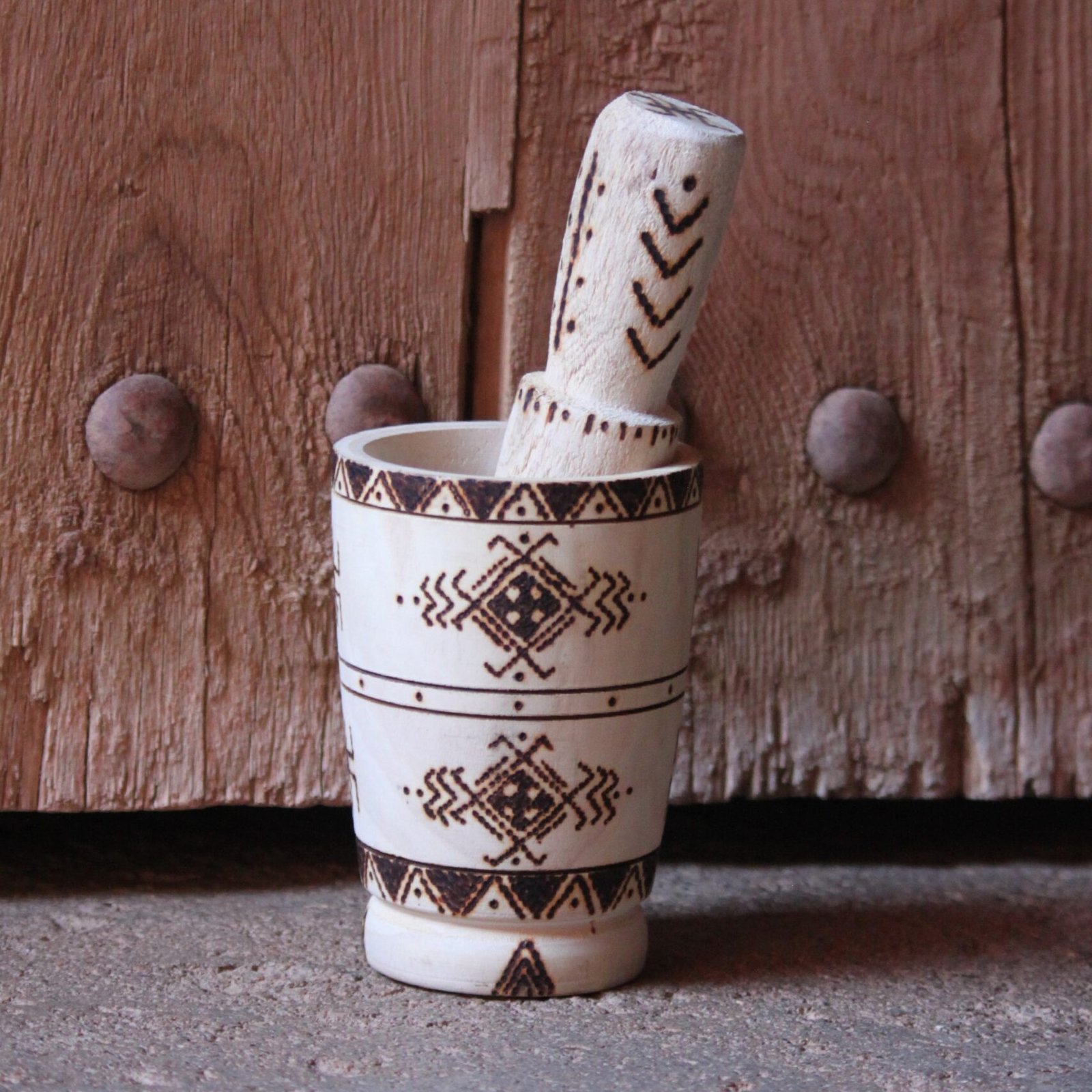 Mortier et pilon artisanaux en bois de tamarinier, décorés à la main de motifs géométriques amazighs.