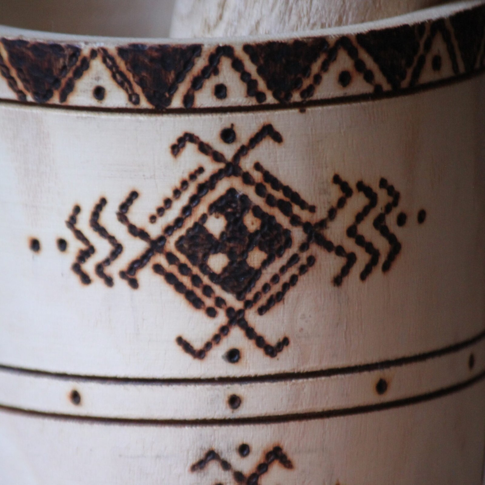 Mortier et pilon artisanaux en bois de tamarinier, décorés à la main de motifs géométriques amazighs.