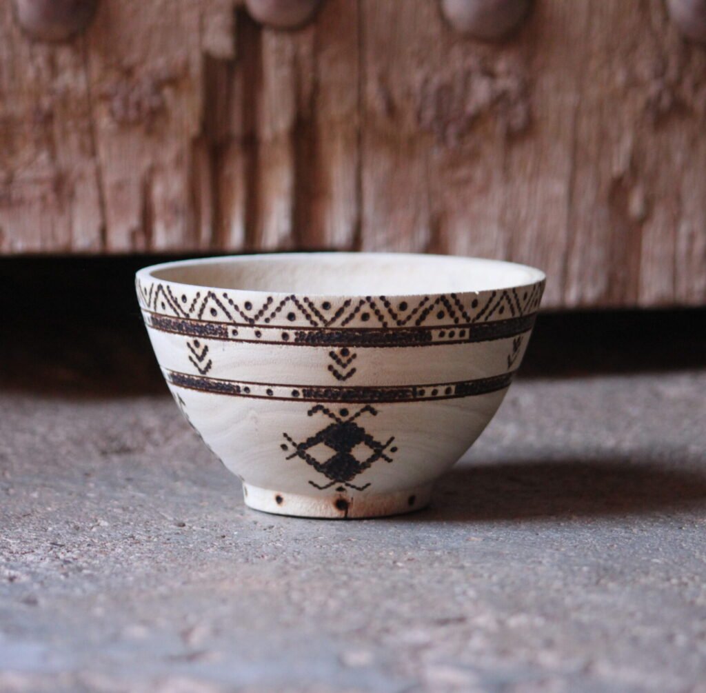 Bol artisanal en bois de tamarinier accompagné de trois cuillères décorées de motifs amazighs.