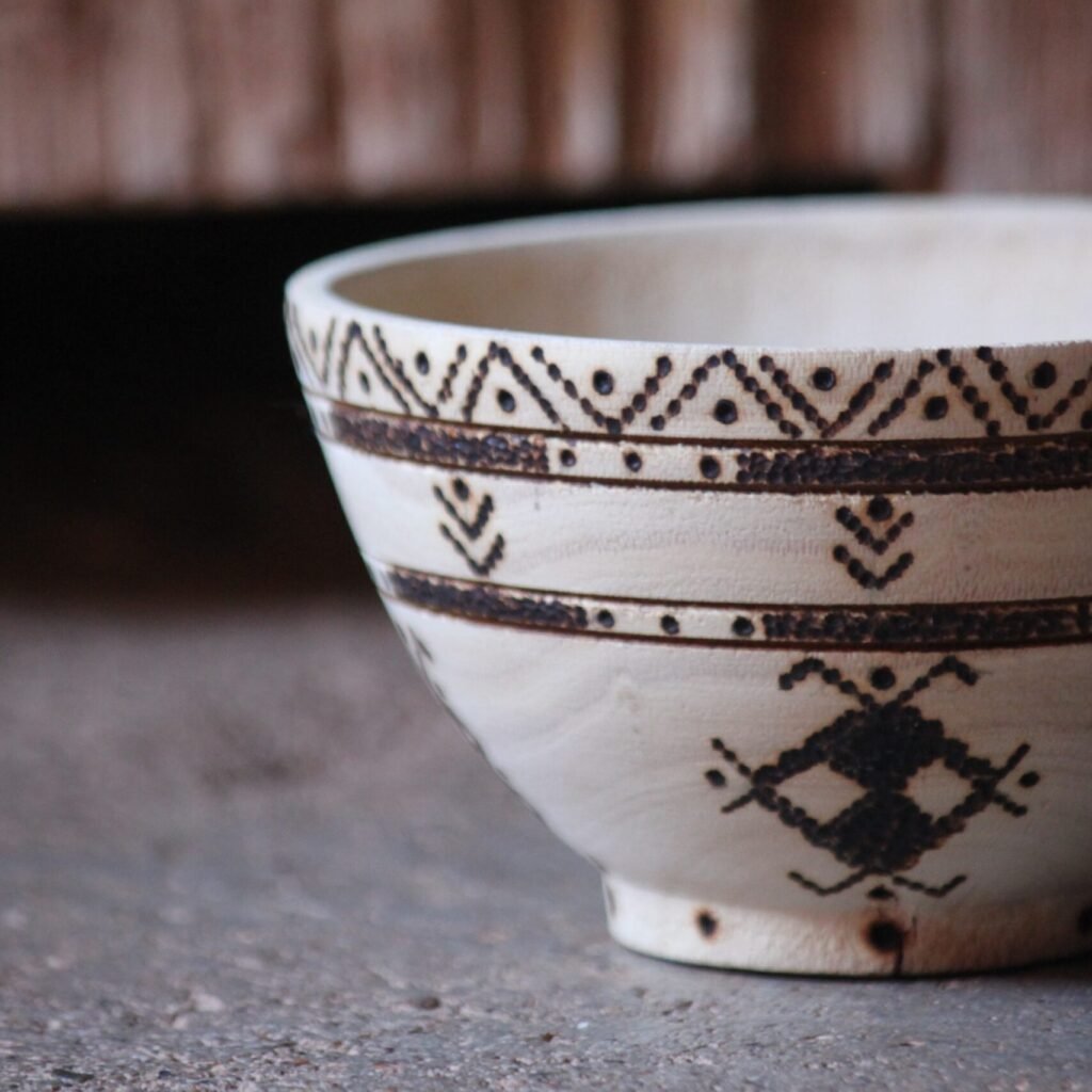 Bol artisanal en bois de tamarinier accompagné de trois cuillères décorées de motifs amazighs.