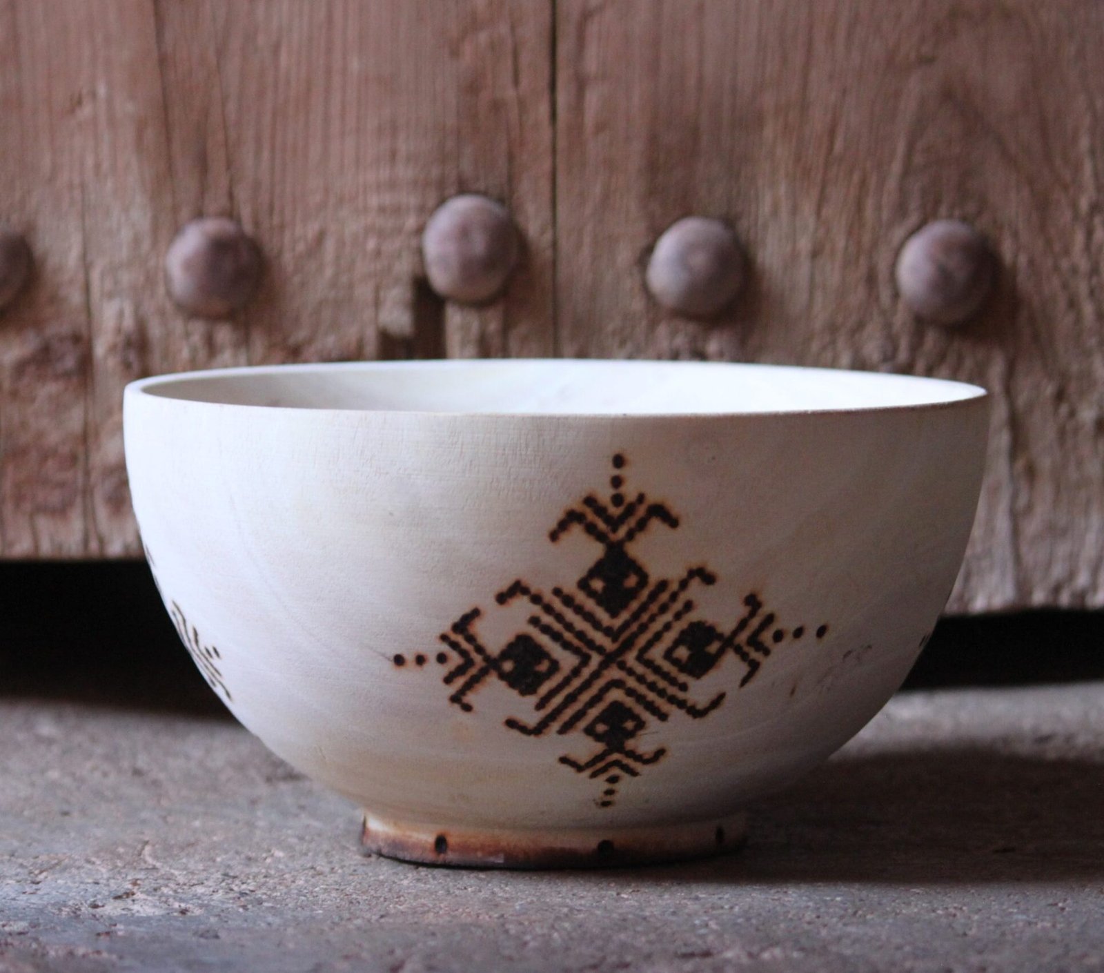 Bol artisanal en bois de tamarinier accompagné de trois cuillères décorées de motifs amazighs.