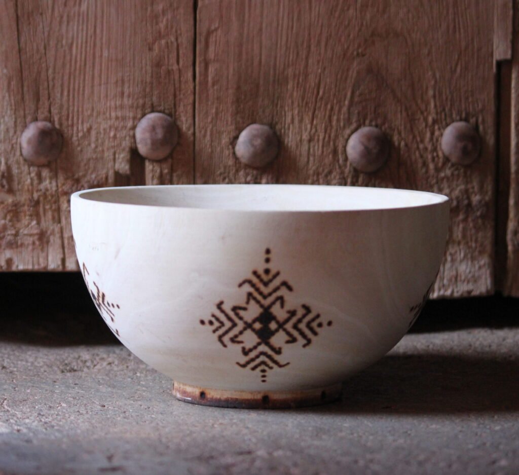 Bol artisanal en bois de tamarinier accompagné de trois cuillères décorées de motifs amazighs.