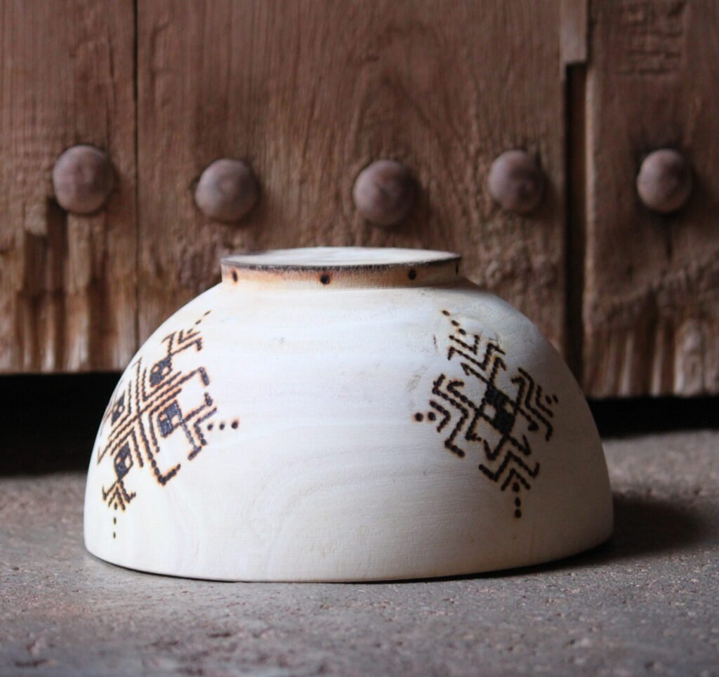 Bol artisanal en bois de tamarinier accompagné de trois cuillères décorées de motifs amazighs.