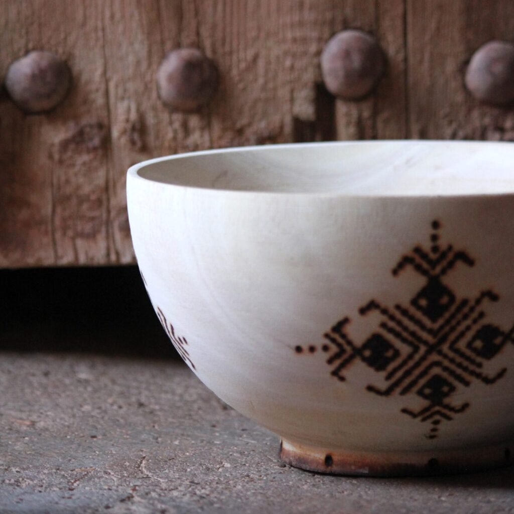 Bol artisanal en bois de tamarinier accompagné de trois cuillères décorées de motifs amazighs.