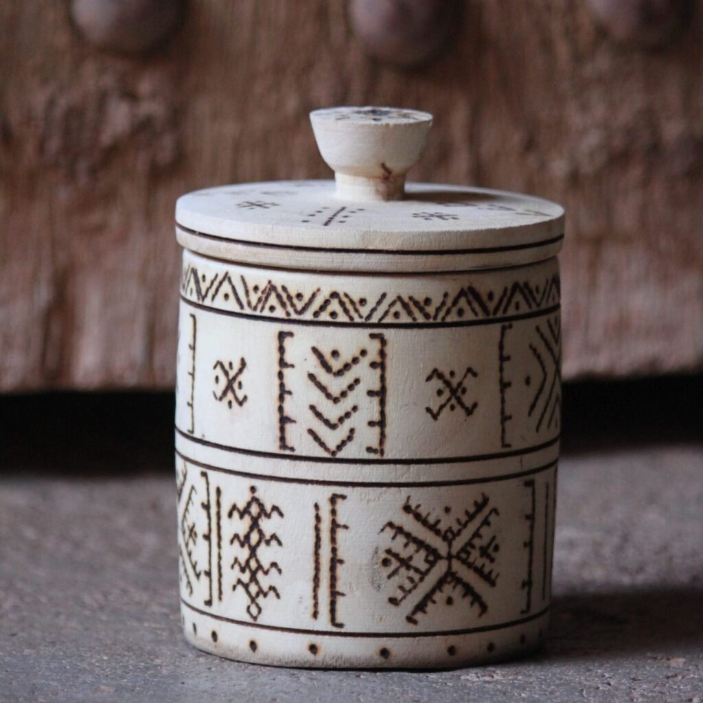 Boîte cylindrique artisanale en bois de tamarinier avec couvercle, décorée de motifs géométriques amazighs.