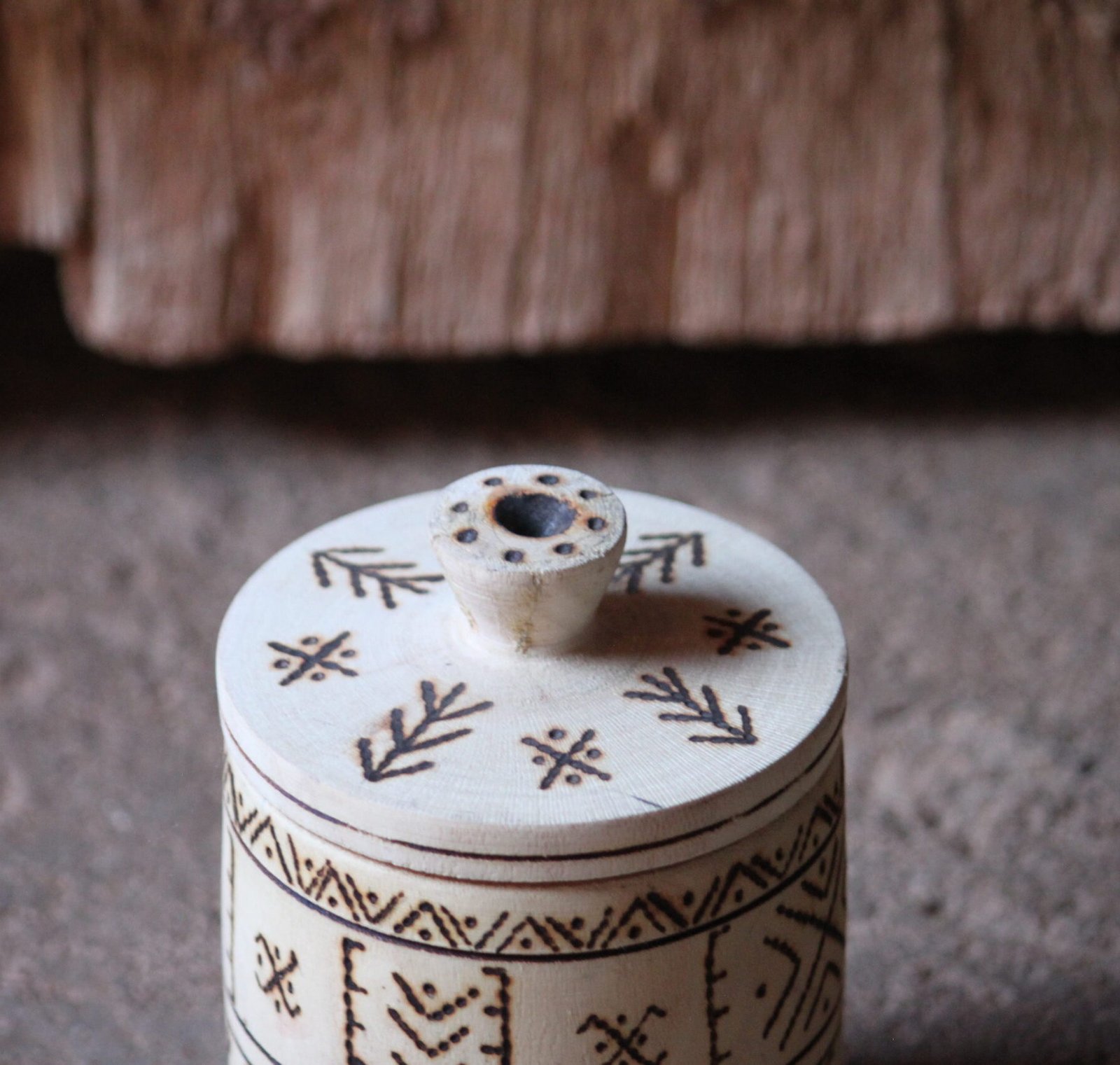 Boîte cylindrique artisanale en bois de tamarinier avec couvercle, décorée de motifs géométriques amazighs.
