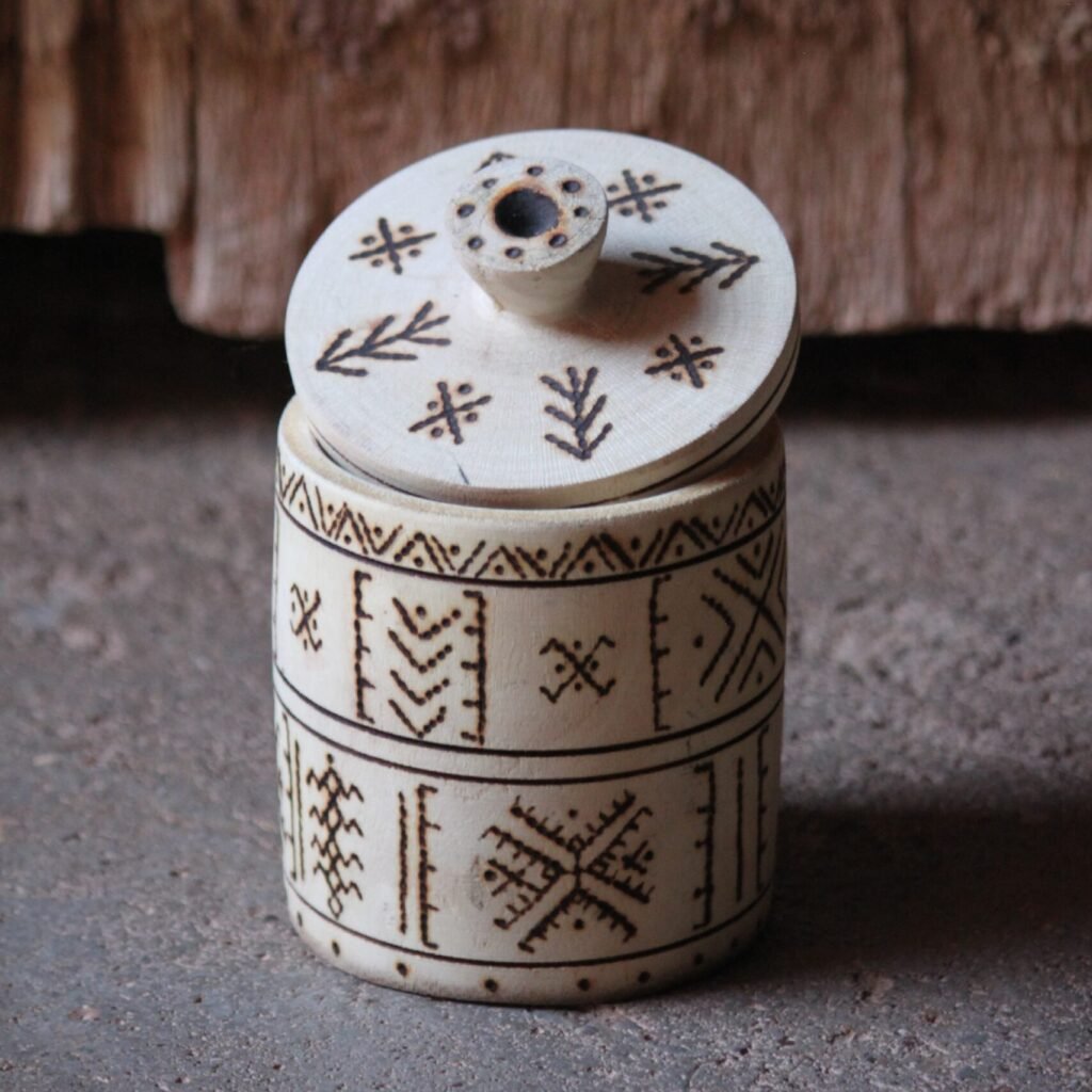 Boîte cylindrique artisanale en bois de tamarinier avec couvercle, décorée de motifs géométriques amazighs.