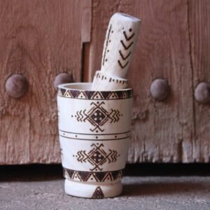 Mortier et pilon artisanaux en bois de tamarinier, décorés à la main de motifs géométriques amazighs.