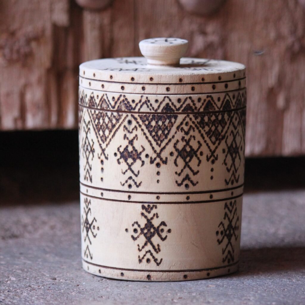 Boîte cylindrique artisanale en bois de tamarinier avec couvercle, décorée de motifs géométriques amazighs.