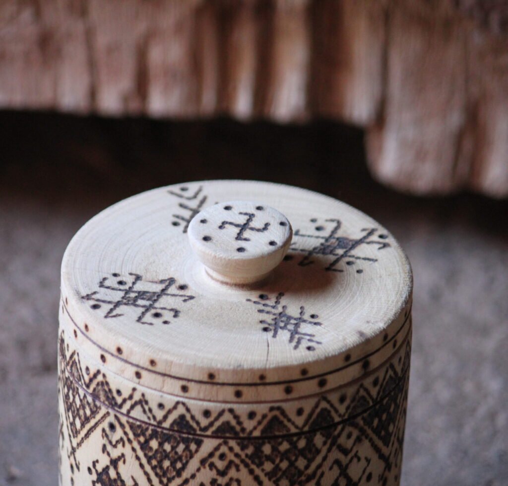 Boîte cylindrique artisanale en bois de tamarinier avec couvercle, décorée de motifs géométriques amazighs.