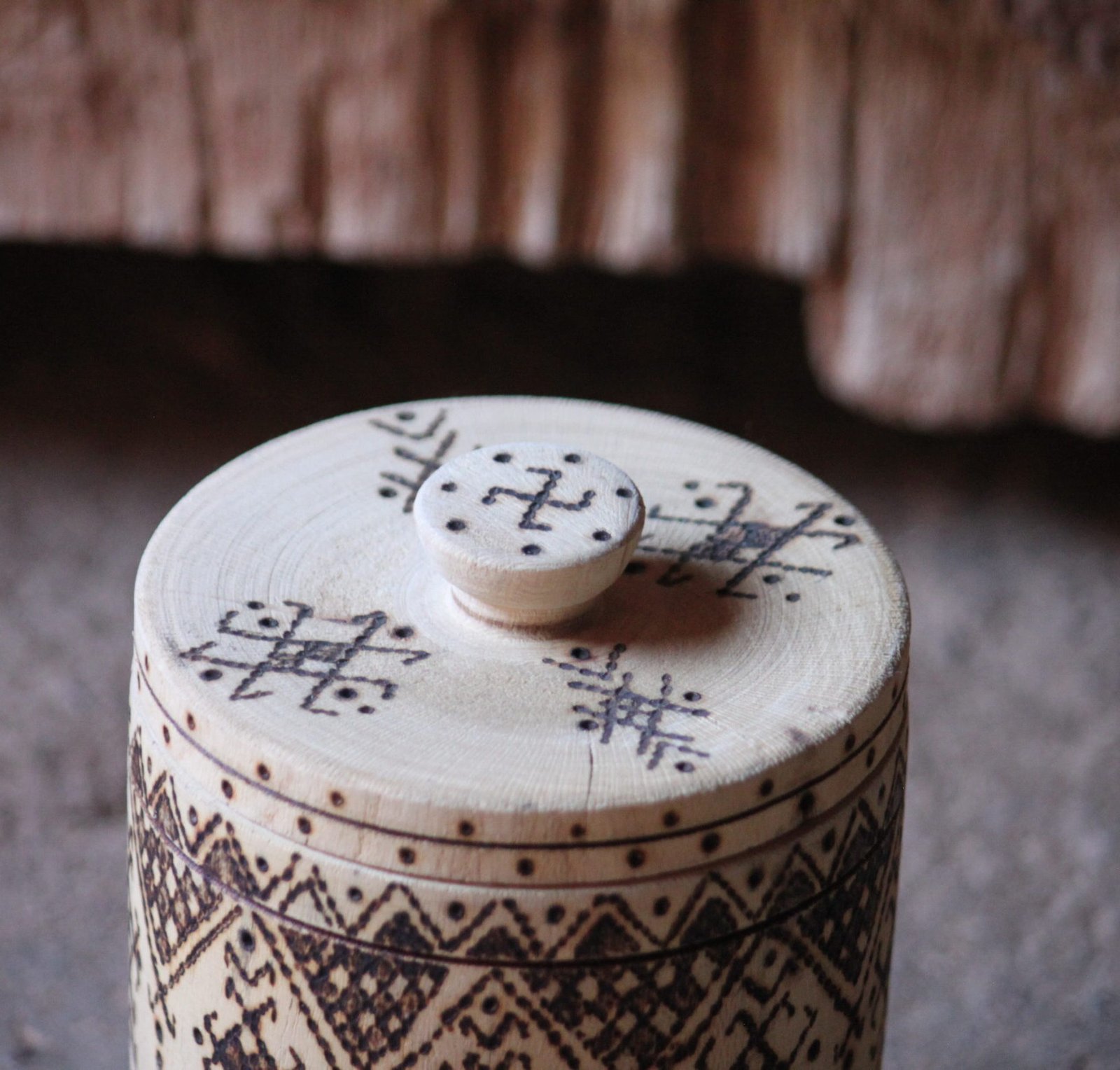 Boîte cylindrique artisanale en bois de tamarinier avec couvercle, décorée de motifs géométriques amazighs.