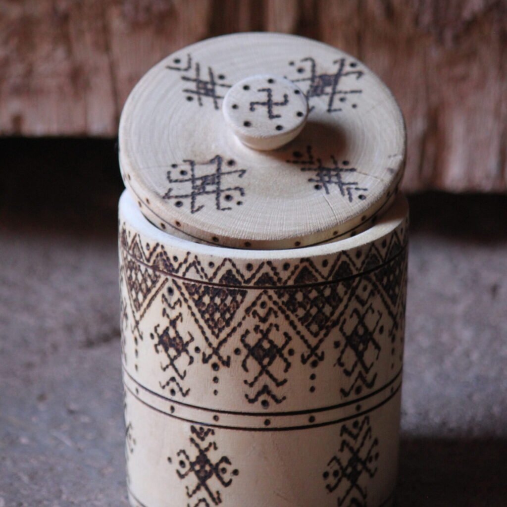 Boîte cylindrique artisanale en bois de tamarinier avec couvercle, décorée de motifs géométriques amazighs.