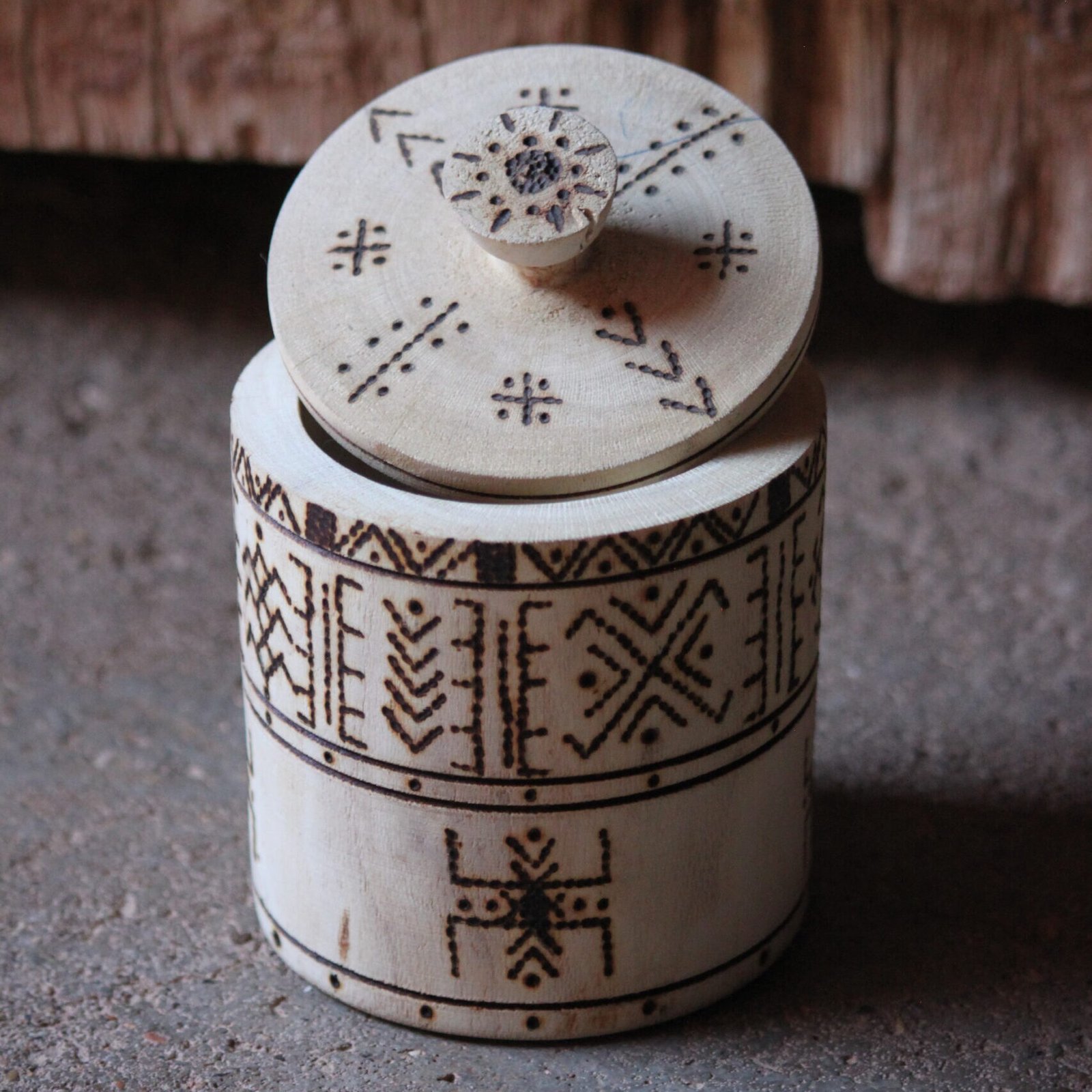 Boîte cylindrique artisanale en bois de tamarinier avec couvercle, décorée de motifs géométriques amazighs.